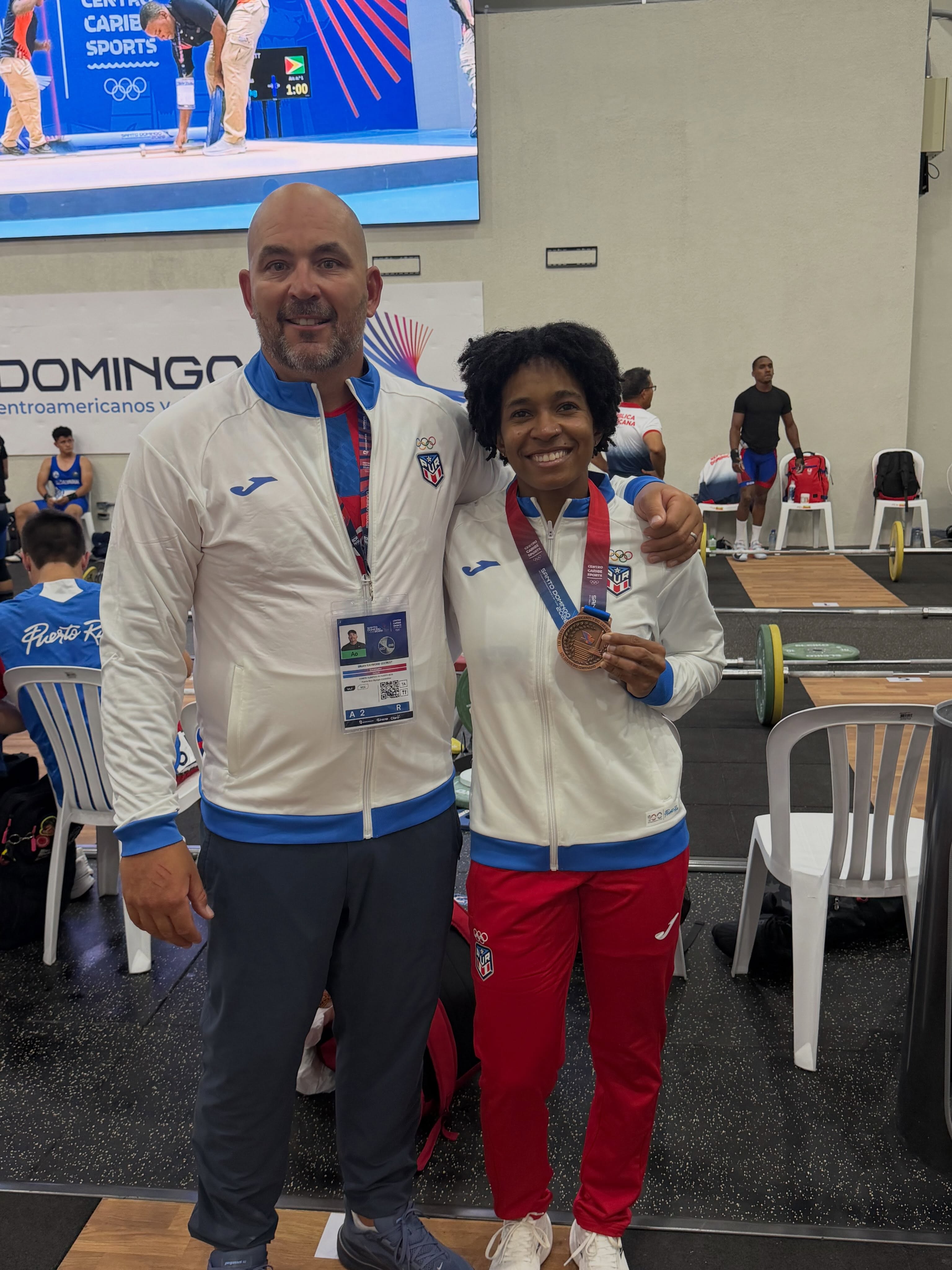 Coach and medal-winning athlete at an international competition