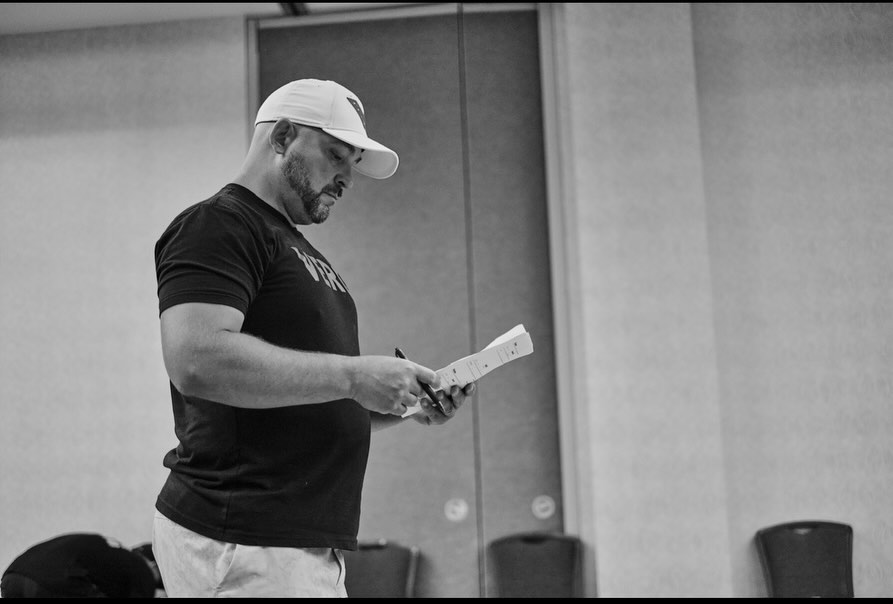Weightlifting coach reviewing training notes